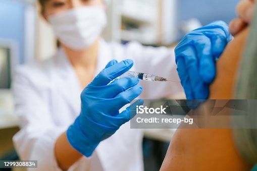 istock Senior adult man getting vaccinated in doctor`s office 1299308834