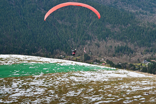 Paraglider Taking Off Tiger Mountain State Forest, Washington, USA - March 07, 2012: A senior adult paraglider takes off from Poo Poo Point. jeff goulden paragliding stock pictures, royalty-free photos & images