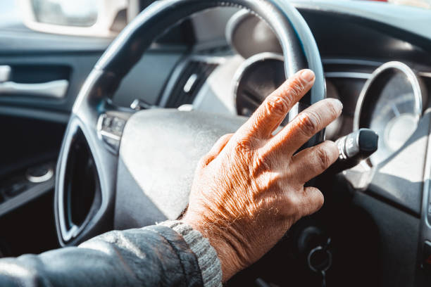 Senior Adult's Hand on the Steering Wheel stock photo