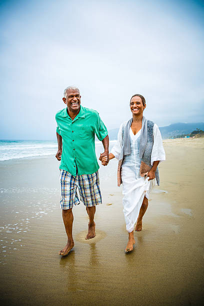 Senior African American couple holding hands Senior African American couple holding hands at beach. Model released. Click for more similar images from this session. old black couple in love stock pictures, royalty-free photos & images