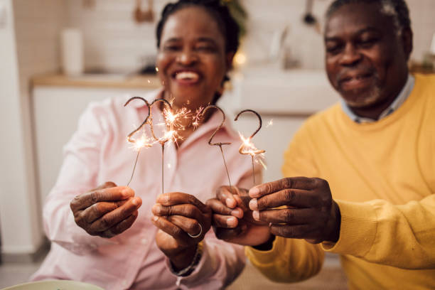 Senior African American couple lighting sprinklers for the 2022 New Year's Eve stock photo