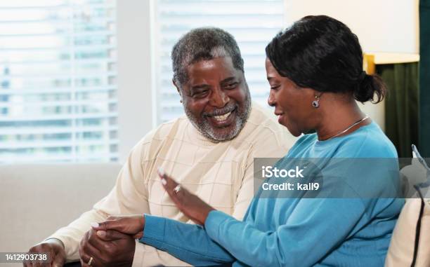Senior African-American couple sitting on couch