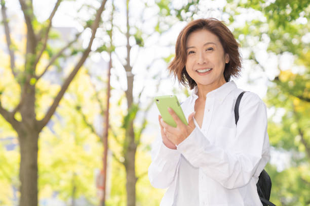 スマートフォンを使用するシニア年齢の女性 - スマホ　女性　日本人 ストックフォトと画像