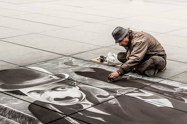 Senior artist during drawing Charlie Chaplin - Paris. stock photo