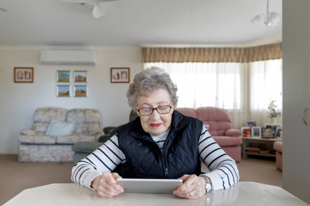 Senior Australian Woman Learning To Use Digital Tablet stock photo