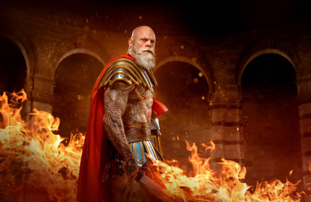 A senior bearded Warrior Gladiator holding a fiery weapon stock photo