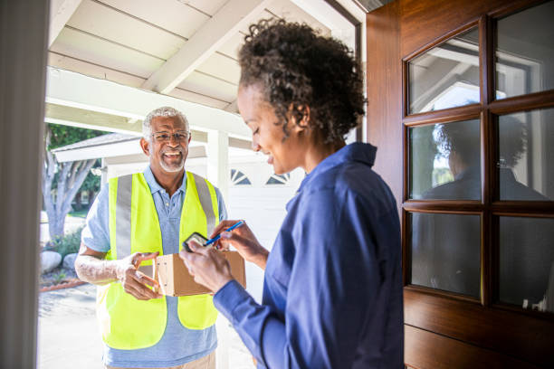 Senior Black Man Delivering Package A senior black man delivers a package to a woman white hair young woman stock pictures, royalty-free photos & images