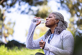 istock Senior black woman drinking water during workout 1334542172