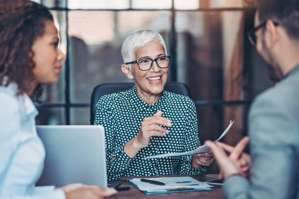 Senior businesswoman talking to her team Group of business person in discussion in the office responsibility stock pictures, royalty-free photos & images