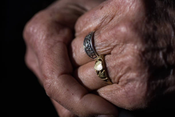 A senior Chinese woman's wrinkled hands with rings on her fingers stock photo