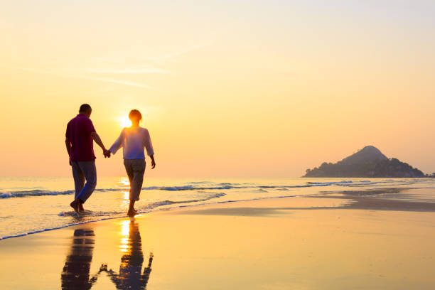 年配のカップルにゴールドのビーチ - 退職金 ストックフォトと画像