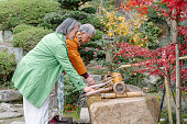 日本のお寺で手を掃除する先輩夫婦