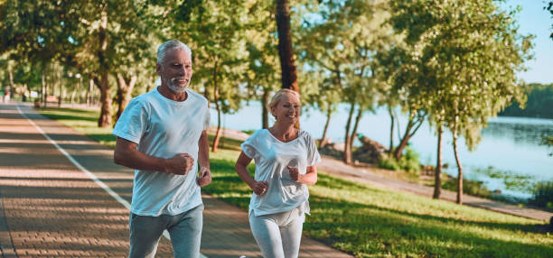 Senior couple doing sport outdoors Senior couple is doing sport outdoors. Running in park in the morning. midsection stock pictures, royalty-free photos & images