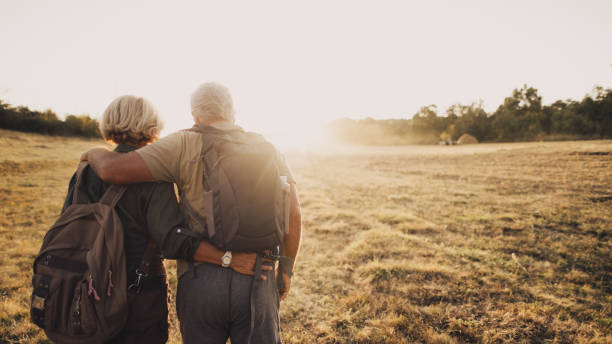 Senior couple hiking Photo of an elderly couple who still enjoy making memories, searching for new adventures while backpacking; wide photo dimensions active lifestyle photos stock pictures, royalty-free photos & images