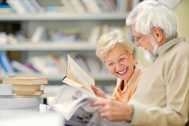 Senior couple in coffee shop have fun and reading stock photo