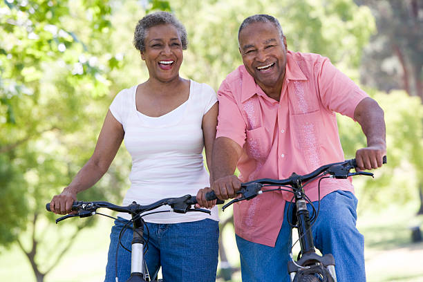 Senior couple on cycle ride Senior couple on cycle ride in countryside approaching stock pictures, royalty-free photos & images
