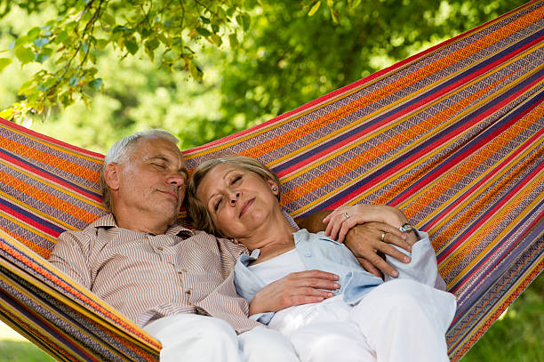 Senior couple relax sleeping in hammock stock photo