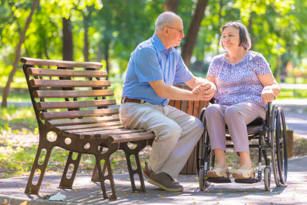 Senior couple relaxed talking on the park bench stock photo