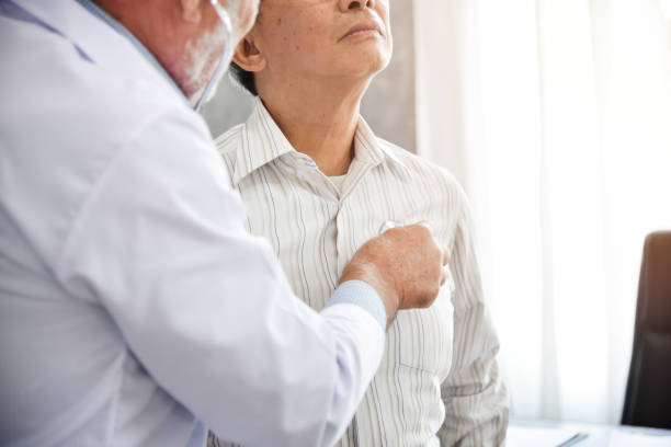 Senior Doctor is examining An Asian patient. stock photo