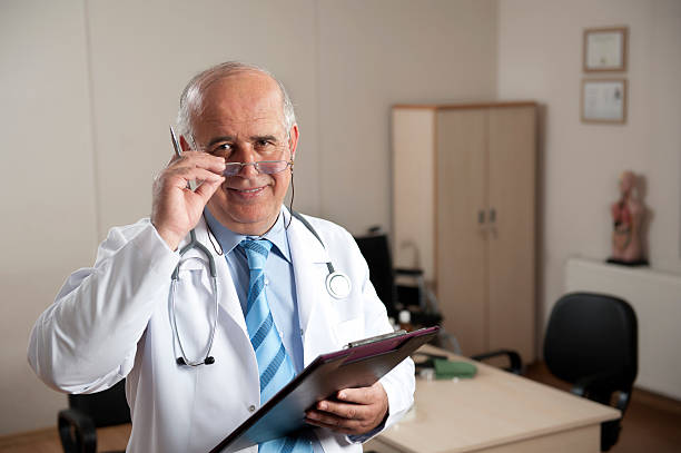 Senior Doctor Senior male doctor portrait. medical degrees stock pictures, royalty-free photos & images