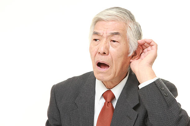 シニア日本のビジネスマンに手、耳で聞くよく - 聴こえない ストックフォトと画像