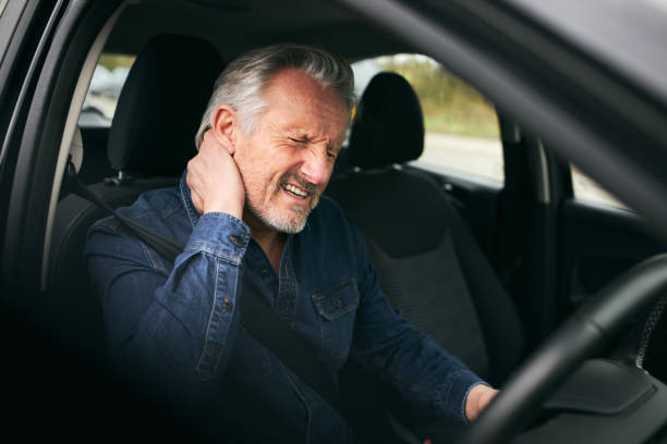 hogere mannelijke bestuurder binnen auto na verkeersongeval dat aan whiplashverwonding lijdt - fixing car pain stockfoto's en -beelden