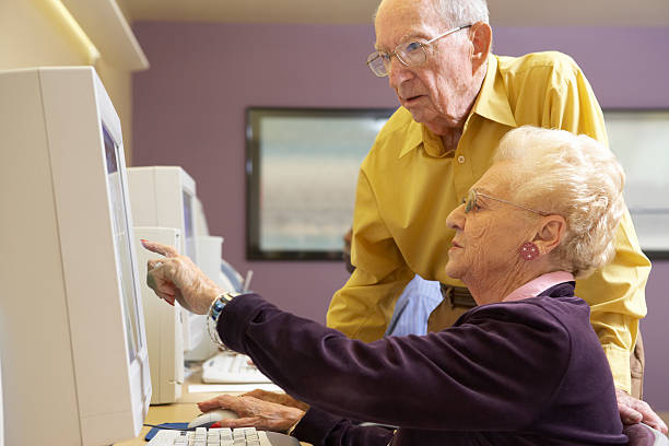 Senior man and woman using computer in residential home