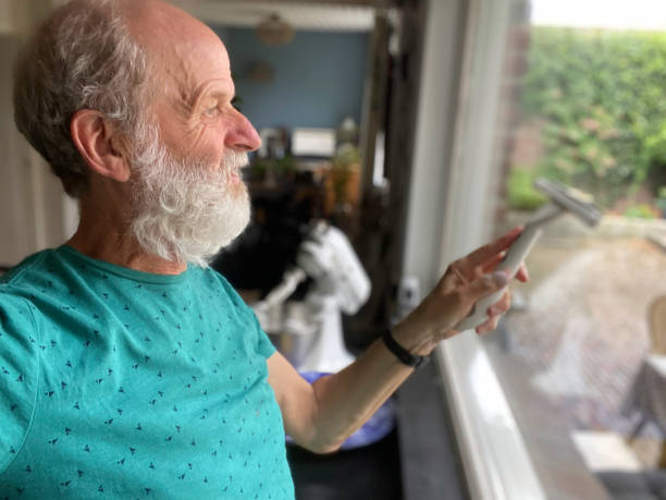 Senior man Cleaning window stock photo