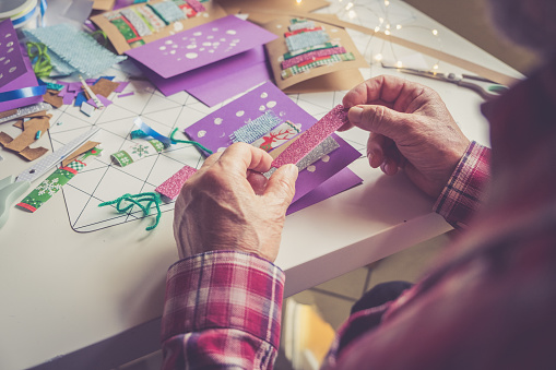 Senior man creating Christmas Cards at home