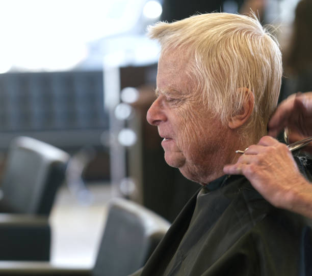 Senior man having his hair styled stock photo