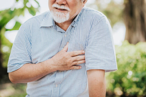 Senior man holding his chest and feeling pain Cropped shot of senior man holding his chest and feeling pain suffering from heart attack outdoor at the park chest pain stock pictures, royalty-free photos & images