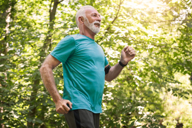 senior mann joggen am morgen gesund leben - 60 69 jahre stock-fotos und bilder