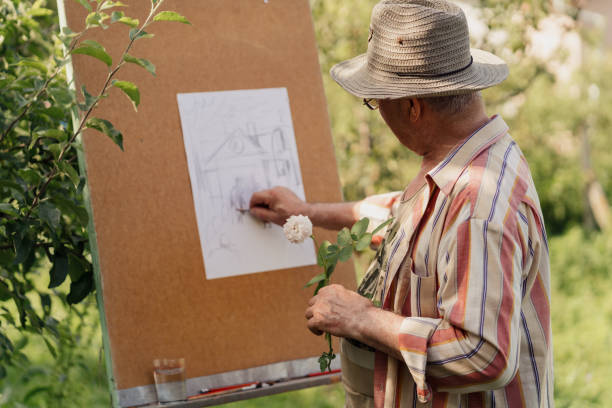 Senior man painting in his garden stock photo