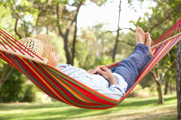 senior man relaxing in hammock - hängmatta bildbanksfoton och bilder