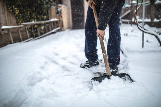 Senior man removing snow from his back yard stock photo
