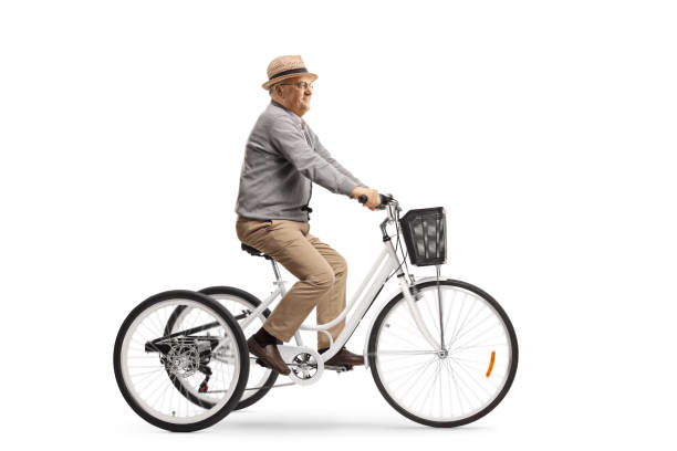 Senior man riding a white tricycle Senior man riding a white tricycle isolated on white background adult tricycle stock pictures, royalty-free photos & images