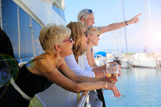 Senior man showing something to their friends on a yacht stock photo