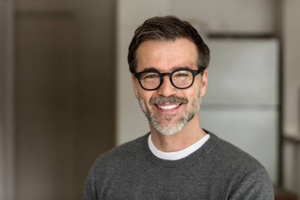 Senior Man Smiling At The Camera. In the kitchen stock photo