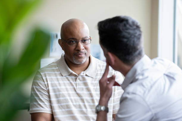 Senior man speaking with a counselor in office stock photo