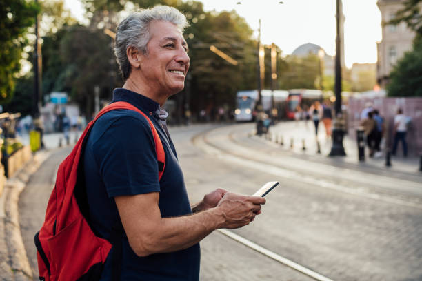 senior man standing on the street - mobile phone imagens e fotografias de stock