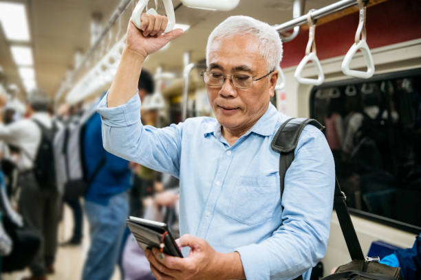 senior man text messaging op de trein pendelen - subway snapshot stockfoto's en -beelden