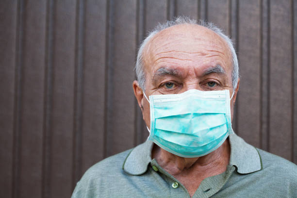 Senior man wearing a protective face mask stock photo