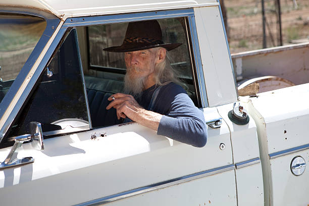 Senior Man With Cowboy Hat Sitting in Vehicle stock photo