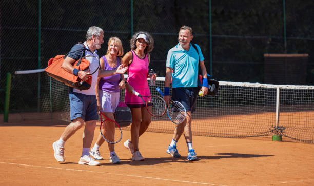 Senior Men And Women Standing Together On A Tennis Court stock photo