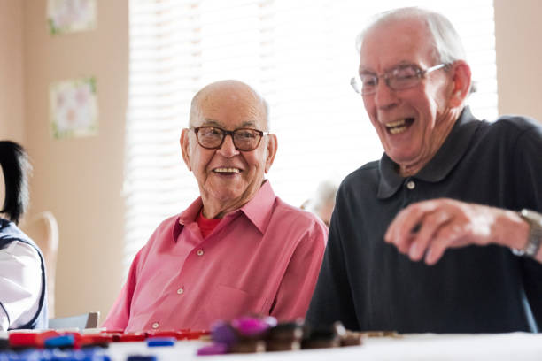 Senior men laughing playing bingo together stock photo