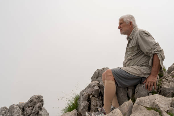 Senior men sitting on the rock in mountains stock photo