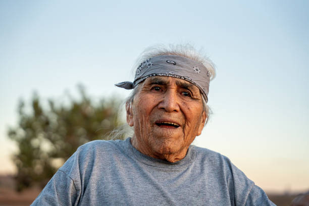 Senior Navajo Native American man Portrait, in his back yard on a sunny late afternoon, at Monument Valley Utah or Arizona smiling at the camera stock photo