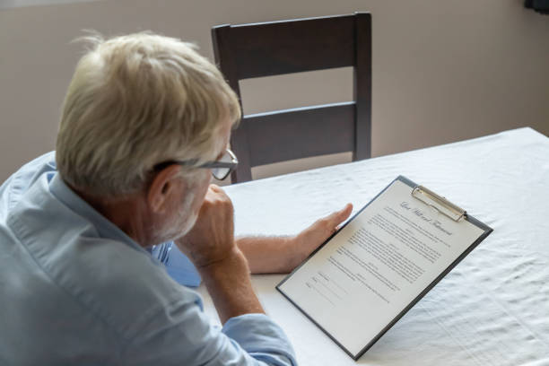 Senior old man elderly examining and checking last will and testament stock photo