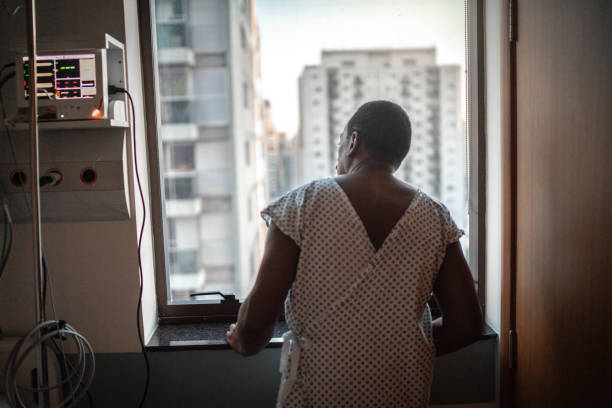 Senior patient looking through window at hospital Senior patient looking through window at hospital sad old black man stock pictures, royalty-free photos & images