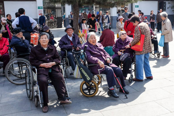 Senior people rest and enjoy sunshine in Tuanjiehu park in Beijing. stock photo
